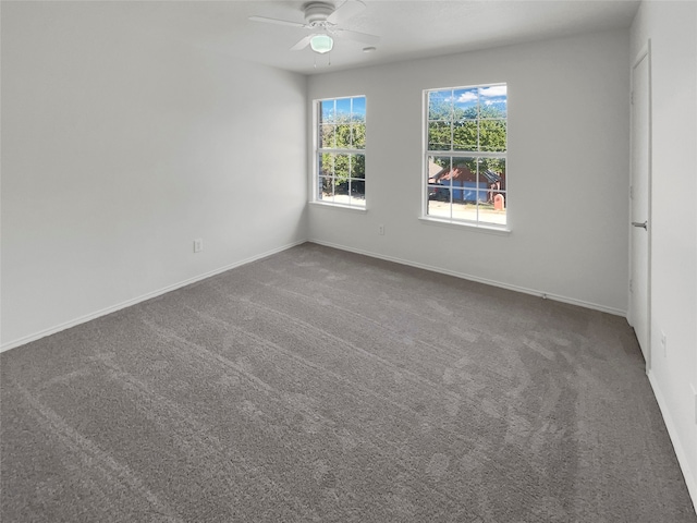 spare room featuring ceiling fan and dark colored carpet