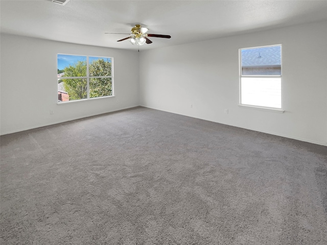 carpeted empty room with a healthy amount of sunlight and ceiling fan