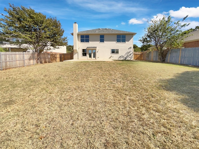 rear view of house featuring a lawn