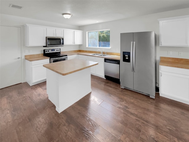 kitchen with a center island, appliances with stainless steel finishes, dark hardwood / wood-style floors, and white cabinets