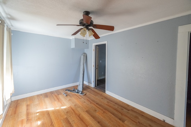 unfurnished bedroom featuring ornamental molding, wood-type flooring, and ceiling fan