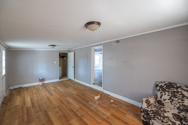 empty room featuring light hardwood / wood-style floors and crown molding