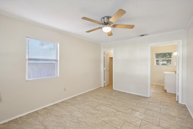 spare room featuring a wealth of natural light, ceiling fan, a textured ceiling, and ornamental molding