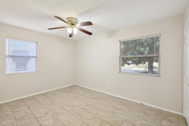 unfurnished room featuring ceiling fan, plenty of natural light, and a textured ceiling