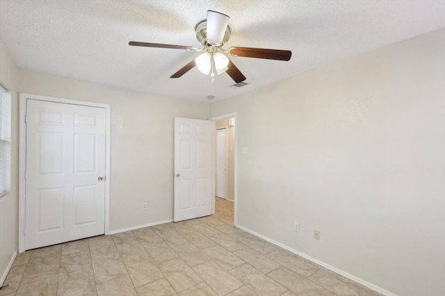 unfurnished bedroom featuring a textured ceiling and ceiling fan