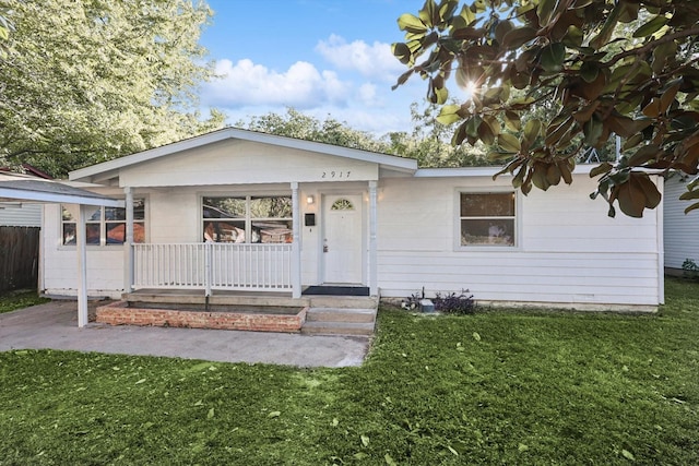 ranch-style home featuring a front lawn and covered porch