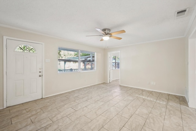 foyer entrance with ceiling fan, ornamental molding, and a textured ceiling