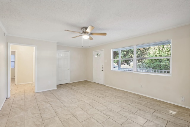 spare room with a textured ceiling, ceiling fan, and crown molding