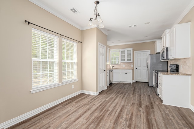 kitchen with appliances with stainless steel finishes, white cabinetry, and a wealth of natural light