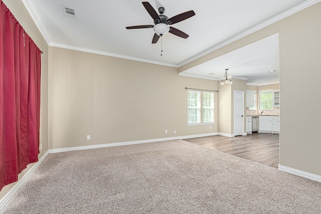 unfurnished room featuring crown molding, ceiling fan with notable chandelier, and light wood-type flooring