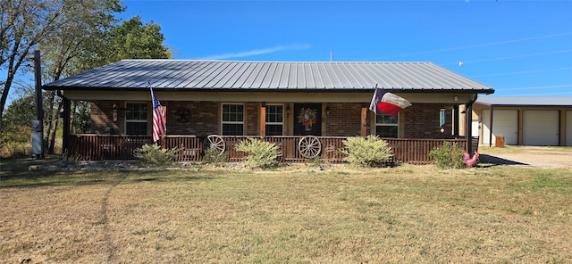 view of front of property featuring covered porch, a front yard, and a garage