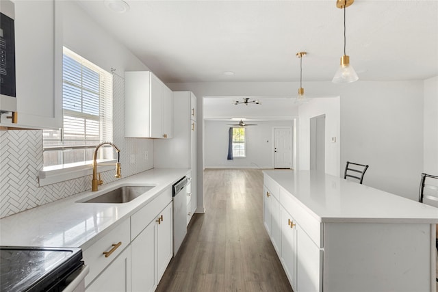 kitchen with white cabinetry, hanging light fixtures, and a healthy amount of sunlight