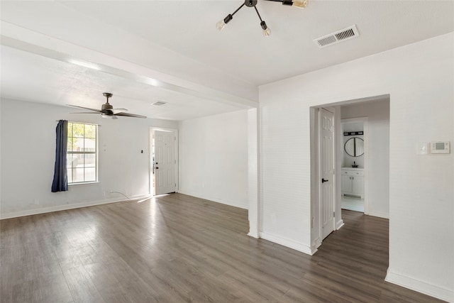 spare room featuring dark wood-type flooring and ceiling fan