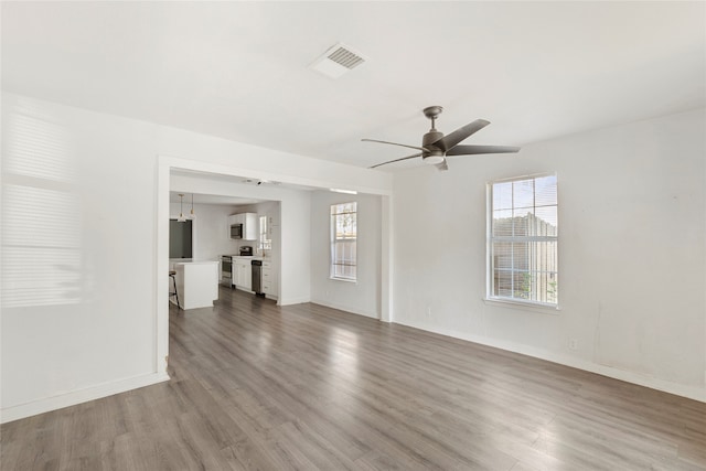 unfurnished living room featuring hardwood / wood-style floors and ceiling fan