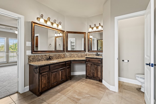 bathroom with toilet, vanity, tile patterned flooring, and ceiling fan