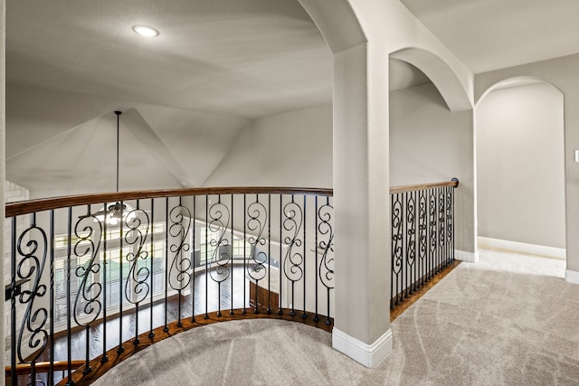 staircase with lofted ceiling and carpet floors