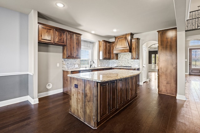 unfurnished living room with a stone fireplace, high vaulted ceiling, dark hardwood / wood-style floors, and ceiling fan