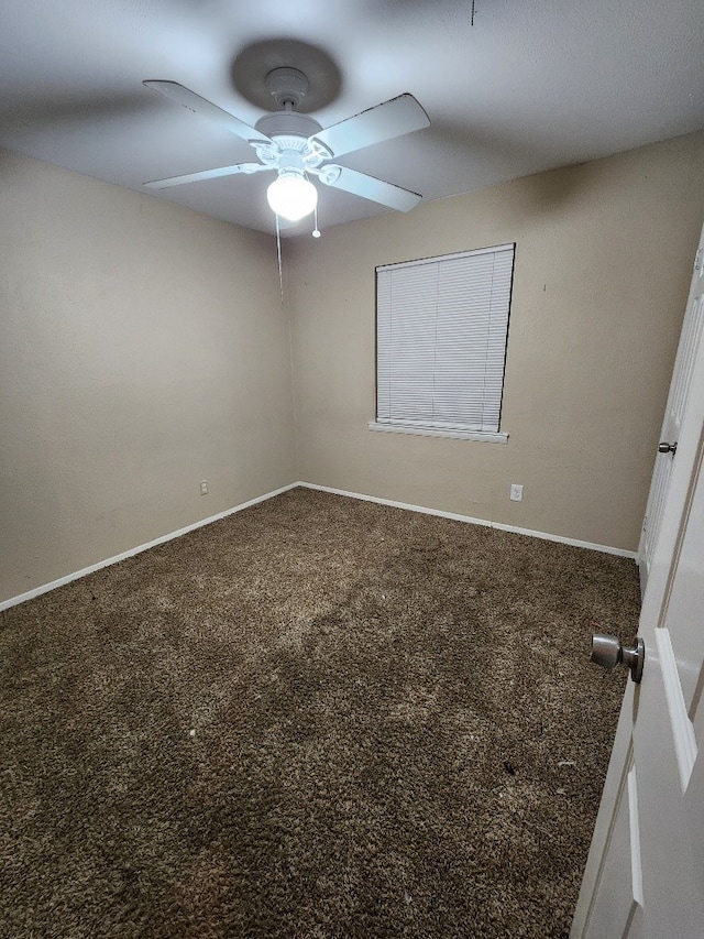 spare room featuring a ceiling fan, baseboards, and carpet