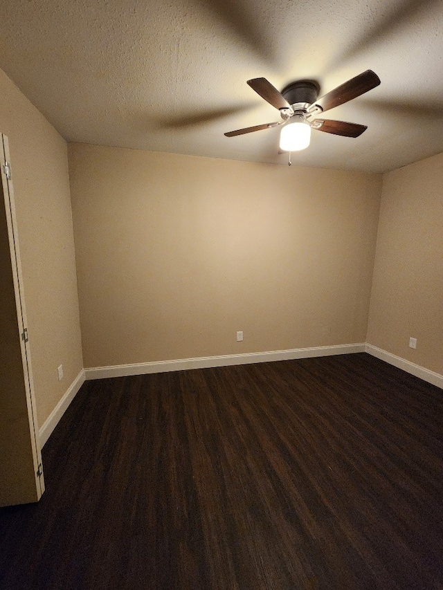 unfurnished room with a textured ceiling, dark wood-type flooring, and ceiling fan