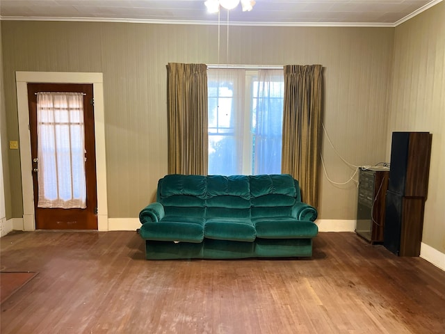 living room featuring baseboards, wood finished floors, and ornamental molding