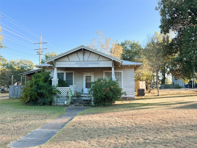 bungalow-style house featuring central air condition unit, a front lawn, fence, and covered porch