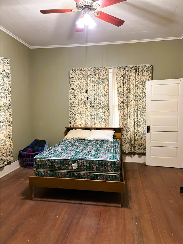 bedroom with wood finished floors, crown molding, and a ceiling fan