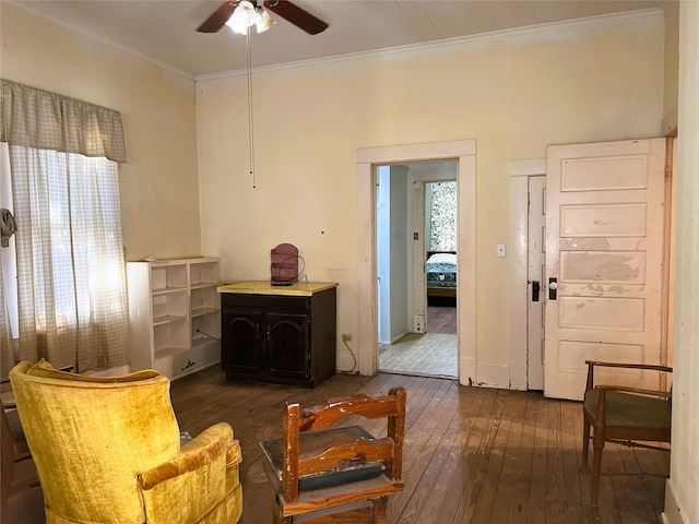 sitting room with hardwood / wood-style floors, crown molding, and ceiling fan