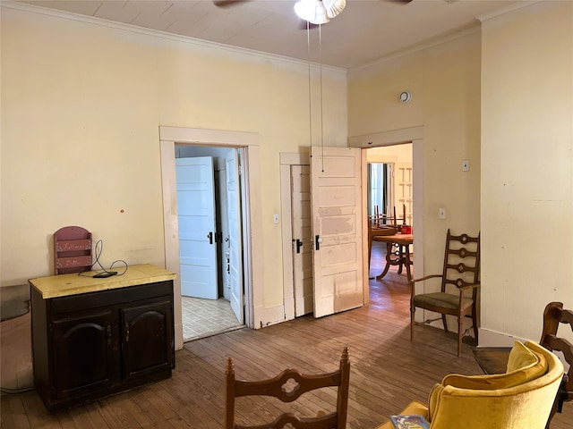 interior space with a ceiling fan, ornamental molding, and dark wood-style flooring