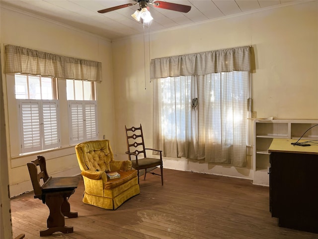 sitting room featuring hardwood / wood-style flooring, a ceiling fan, and crown molding