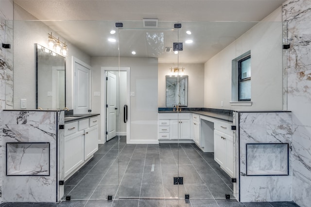 bathroom with walk in shower, vanity, and tile patterned flooring