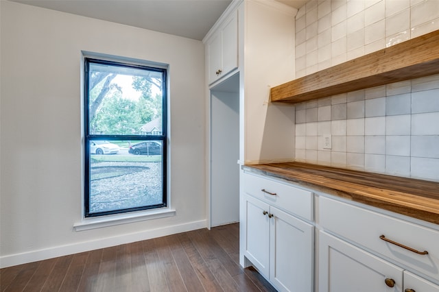 kitchen featuring dark hardwood / wood-style flooring, butcher block countertops, white cabinetry, and decorative backsplash