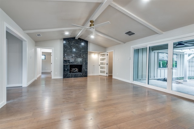 unfurnished living room featuring a premium fireplace, ceiling fan, lofted ceiling with beams, and wood-type flooring