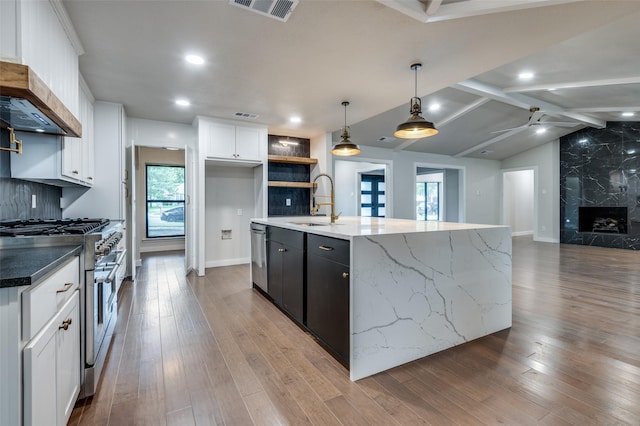 10544 Cox Ln, Dallas, TX 75229 - kitchen featuring stainless steel appliances, open floor plan, white cabinets, wood finished floors, and recessed lighting