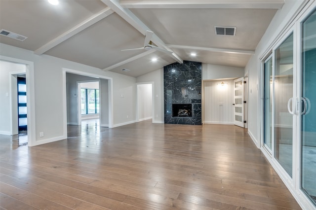 unfurnished living room featuring lofted ceiling with beams, a fireplace, hardwood / wood-style flooring, and ceiling fan