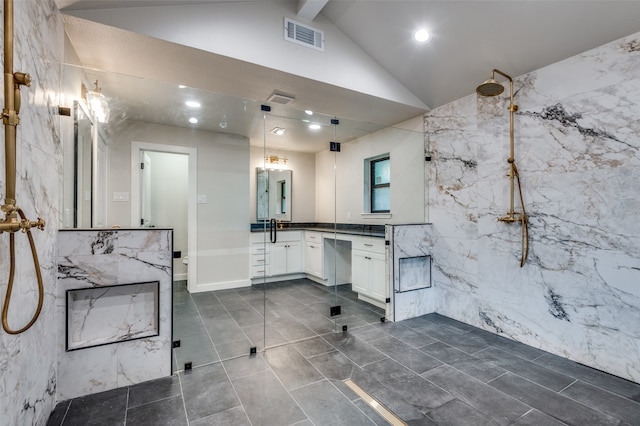 bathroom with tile walls, walk in shower, vanity, and vaulted ceiling