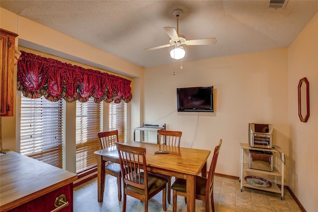 dining area featuring a textured ceiling and ceiling fan