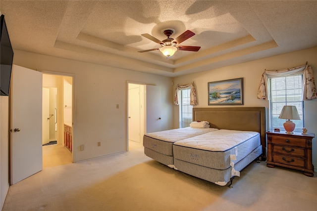 carpeted bedroom featuring ceiling fan, a raised ceiling, and multiple windows