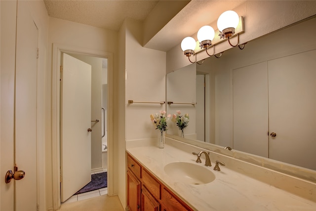 bathroom featuring vanity, a textured ceiling, and tile patterned floors