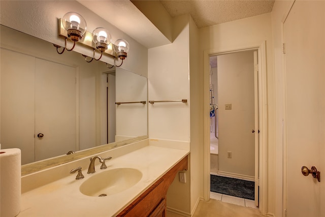 bathroom with vanity, a textured ceiling, and tile patterned flooring