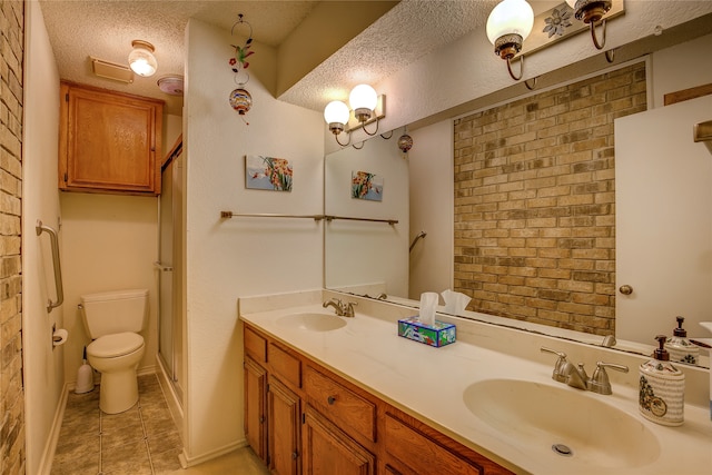 bathroom featuring toilet, a textured ceiling, vanity, and tile patterned floors