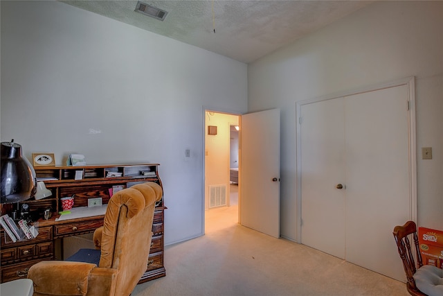 carpeted home office with a textured ceiling and a high ceiling