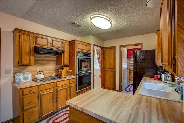 kitchen with sink, black appliances, and a textured ceiling