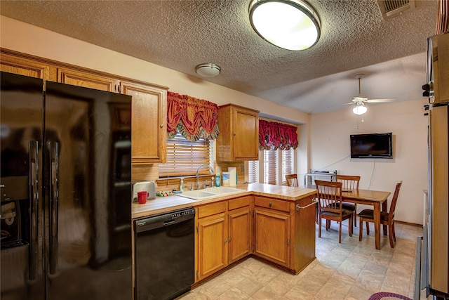 kitchen with kitchen peninsula, ceiling fan, a textured ceiling, black appliances, and sink