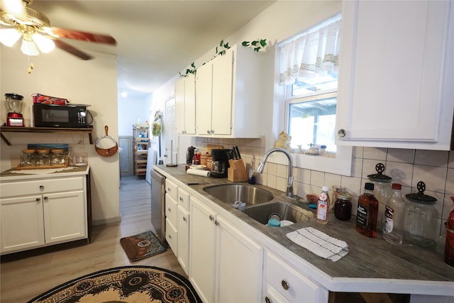 kitchen with decorative backsplash, light hardwood / wood-style flooring, sink, stainless steel dishwasher, and white cabinetry