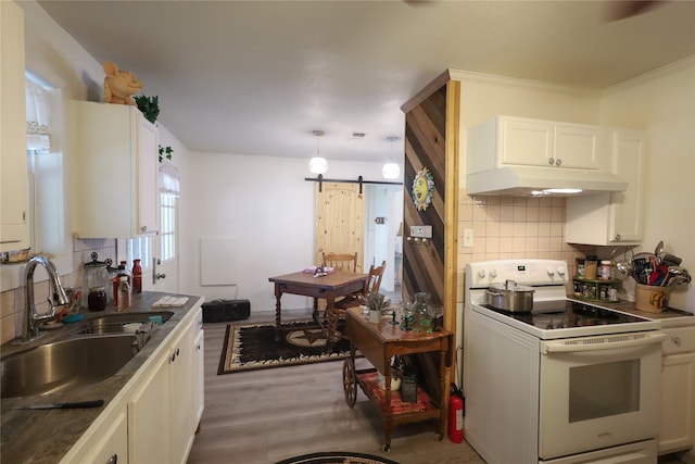 kitchen featuring sink, a barn door, white range with electric stovetop, white cabinets, and light hardwood / wood-style flooring