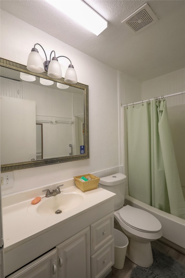 full bathroom featuring a textured ceiling, shower / bath combo, toilet, vanity, and hardwood / wood-style flooring