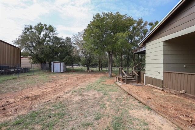 4240 Cheyenne Dr, May, TX 76857 - view of yard with driveway, an outbuilding, stairway, fence, and a shed