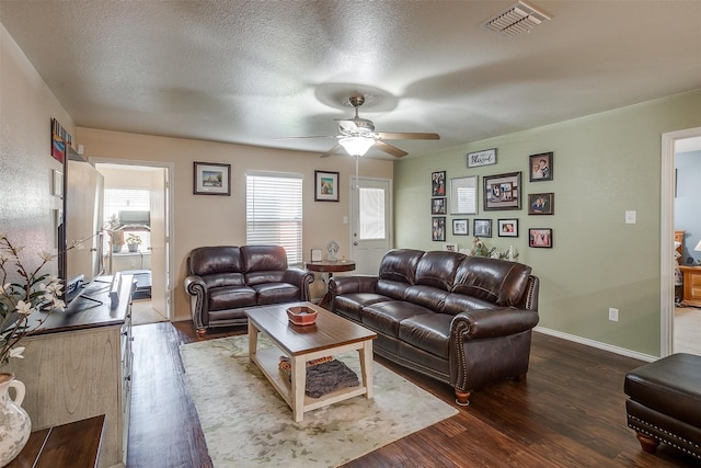 living room with a textured ceiling, dark hardwood / wood-style floors, and ceiling fan