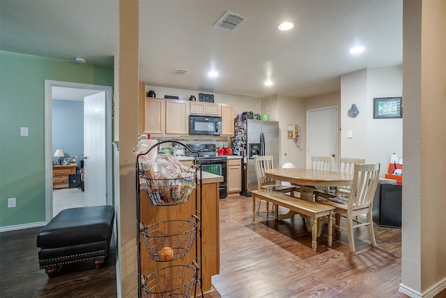 kitchen featuring black appliances, light brown cabinetry, backsplash, and light hardwood / wood-style floors