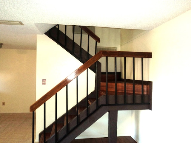 stairway with a textured ceiling